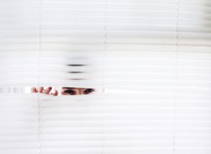 Someone getting a sneak peek through window blinds